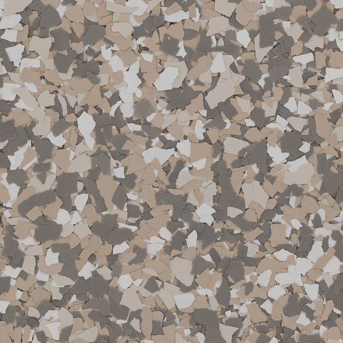 A close-up of a decorative epoxy floor finish with a dense pattern of gray, beige, and white vinyl paint flakes.