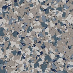 A close-up of a decorative epoxy floor finish with gray, white, and navy blue vinyl flakes.