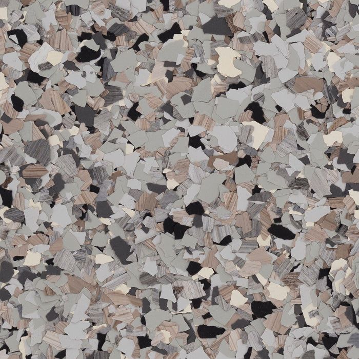 A close-up texture of decorative vinyl floor flakes in a mix of grey, tan, cream, and black fragments.