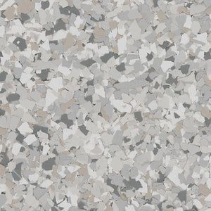 A multi-colored paint chip floor coating in shades of gray, white, and tan, featuring a speckled, textured pattern.