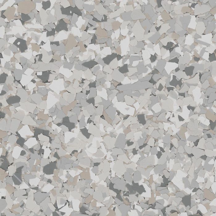 A close-up of a decorative epoxy floor finish with a dense, multi-colored flake pattern in shades of gray, white, and tan.