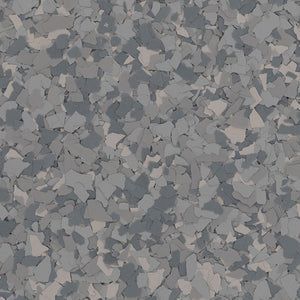 A close-up of grey, blue, and white vinyl color chips embedded in a flooring surface, creating a speckled pattern.