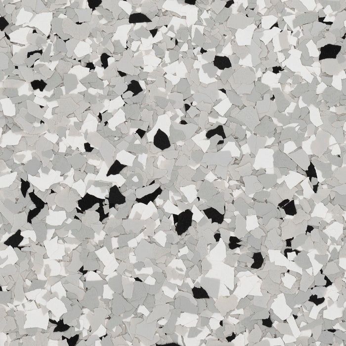 A close-up of a decorative flooring finish featuring a mix of black, white, and grey speckled vinyl flakes.