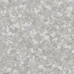 A close-up texture of grey and white vinyl paint flakes used for decorative garage floor coating.