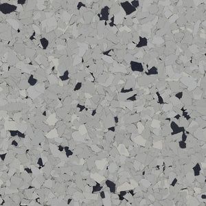 A close-up of grey, white, and black decorative vinyl paint chips, often used for epoxy flooring.