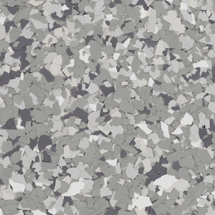 A multi-colored floor flake pattern with various shades of gray, white, and dark charcoal chips in an irregular design.