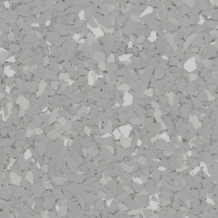 A textured floor surface covered in a dense, mottled pattern of small, overlapping light and dark gray flakes.