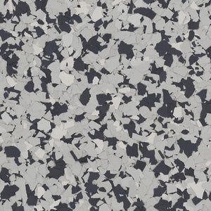 A close-up of a decorative flooring texture with scattered black, grey, and white flakes.