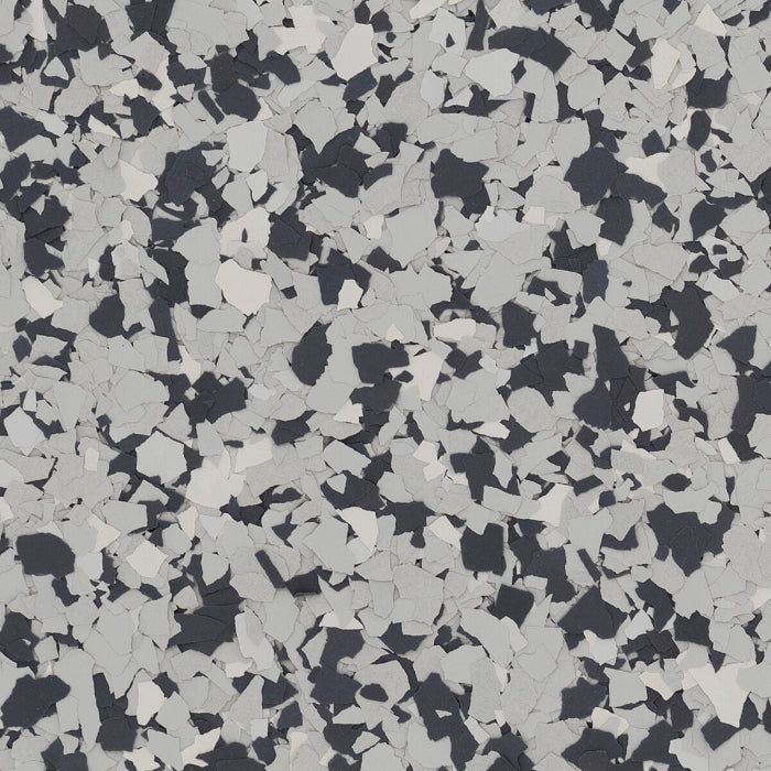 A close-up texture pattern featuring a mix of black, light gray, and white vinyl paint chips for flooring.