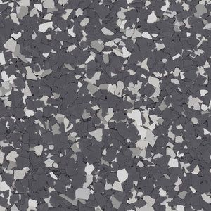 A close-up of a decorative flooring finish featuring a mix of dark gray, medium gray, and white vinyl color chips.