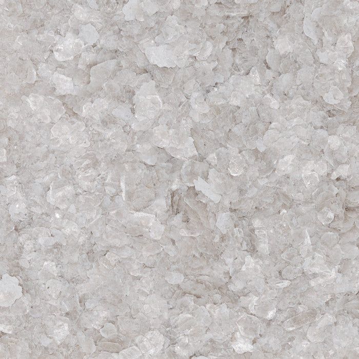 Close-up view of coarse, translucent white sea salt crystals.