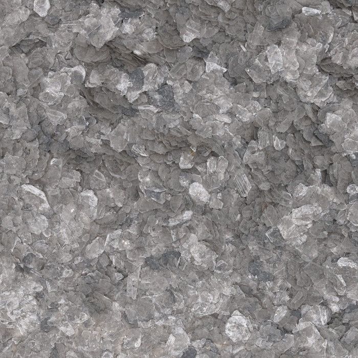 A close-up view of crushed gray and white mineral aggregate or stone pebbles with a textured, rocky appearance.