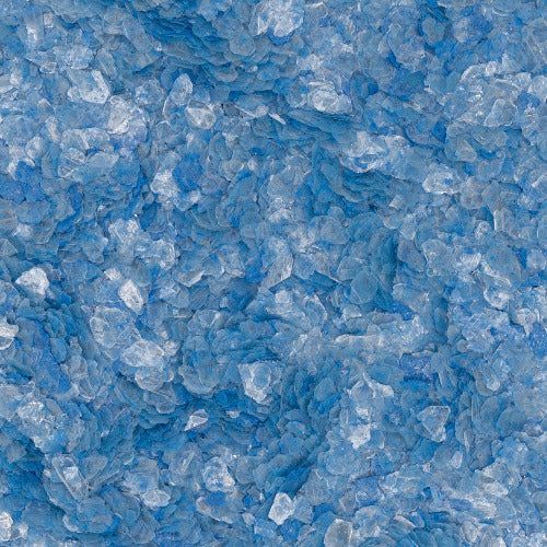 A close-up texture of small, scattered light and dark blue crystals or salt grains.