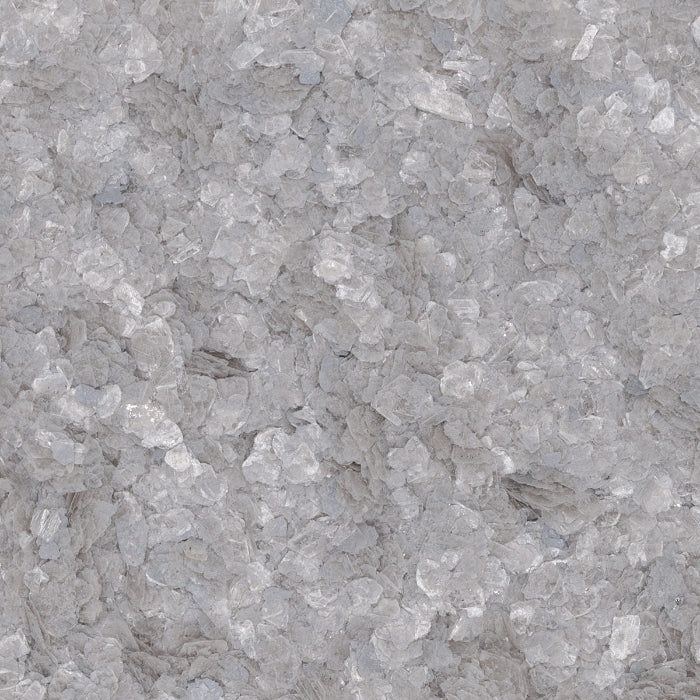 A close-up view of coarse, translucent gray sea salt crystals with varying textures and shapes.