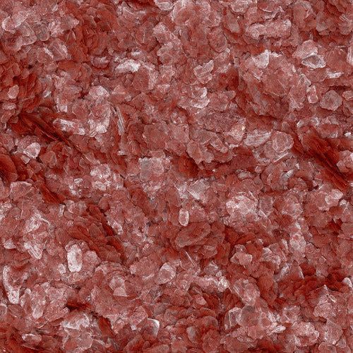 A close-up, top-down view of a pile of coarse, translucent reddish-pink crystal bath salts.