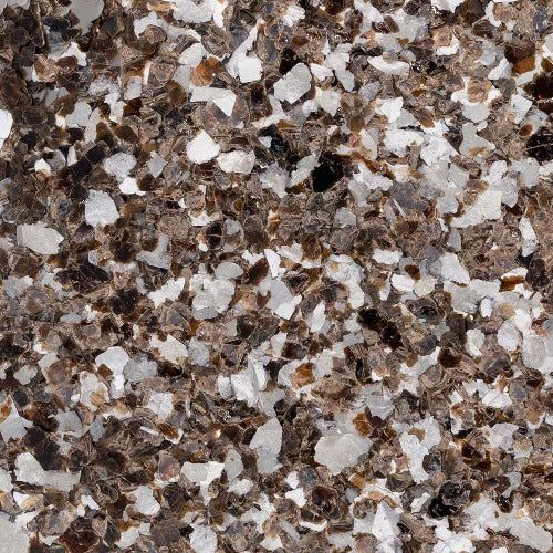 A close-up view of a decorative floor flake blend featuring a mix of brown, white, and gray speckled chips.