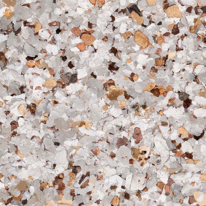 Decorative flooring flakes in a mix of white, gray, tan, and dark brown fragments.