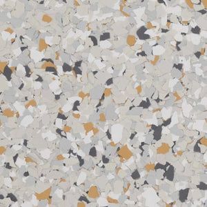 A close-up of decorative epoxy flooring with a speckled pattern in shades of grey, white, tan, and charcoal.