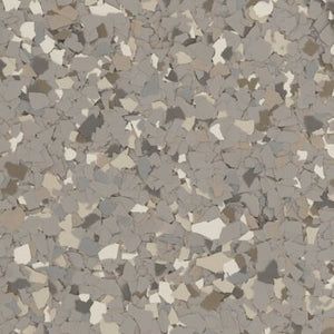 A close-up view of a multi-colored grey and beige vinyl chip flake flooring texture.