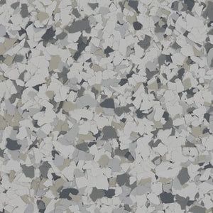 A close-up of light gray, white, and charcoal speckled epoxy floor coating chips.