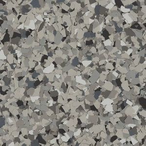 A close-up view of epoxy garage floor coating with a speckled blend of grey, white, and black vinyl color flakes.