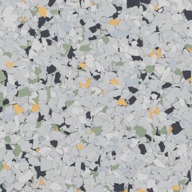 A close-up of a speckled floor coating with grey, white, black, pale green, and yellow vinyl flakes in a random pattern.