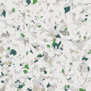 A close-up of decorative vinyl flooring flakes in a mix of white, light gray, tan, and dark green.