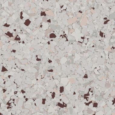 A textured surface with a dense pattern of gray, white, and dark brown paint chips, typical of an epoxy floor coating.