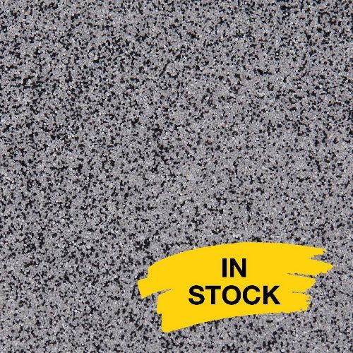 Gray and black granite-like speckled surface with a yellow sticker in the bottom right corner that says 