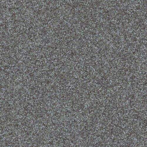 A close-up, high-angle shot of a gray, textured carpet with a speckled, multi-tonal flecked pattern.