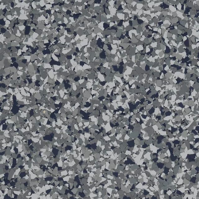 A textured surface with a speckled pattern of small grey, dark charcoal, and white flecks, resembling epoxy flooring.