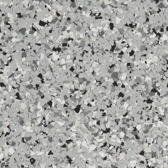 A close-up of gray, black, and white vinyl paint chips used for epoxy floor coating.