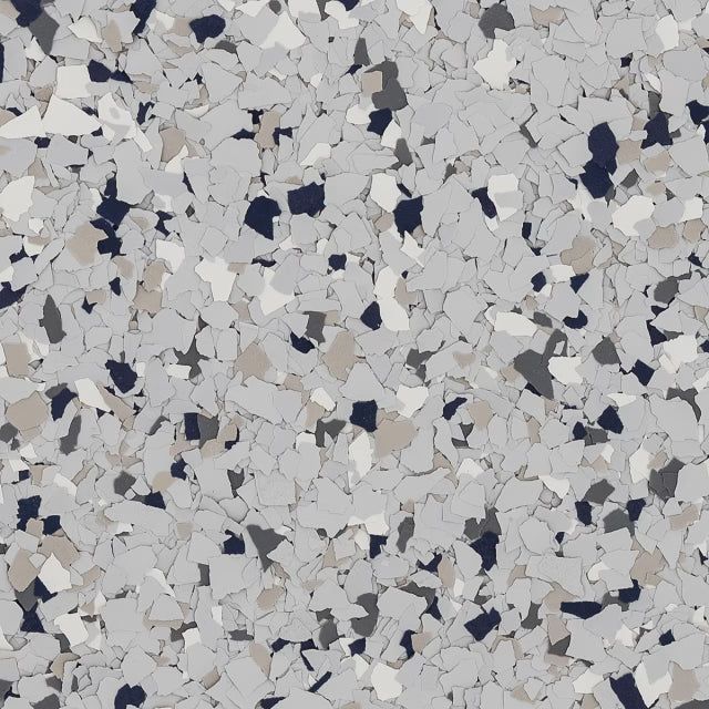 A close-up of a speckled floor texture featuring light gray, dark gray, white, and tan paint flakes.