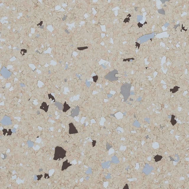 A textured surface featuring a beige base speckled with light blue, white, gray, and dark brown paint flakes.