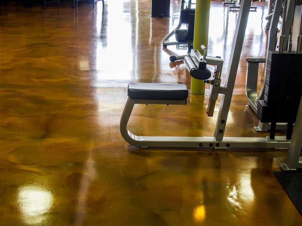 Gym equipment on a high-gloss, amber and brown marble-patterned floor.