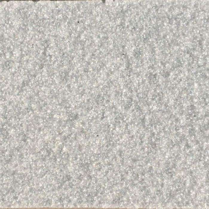 Close-up view of a rough, light gray textured surface, appearing like sandpaper or concrete.