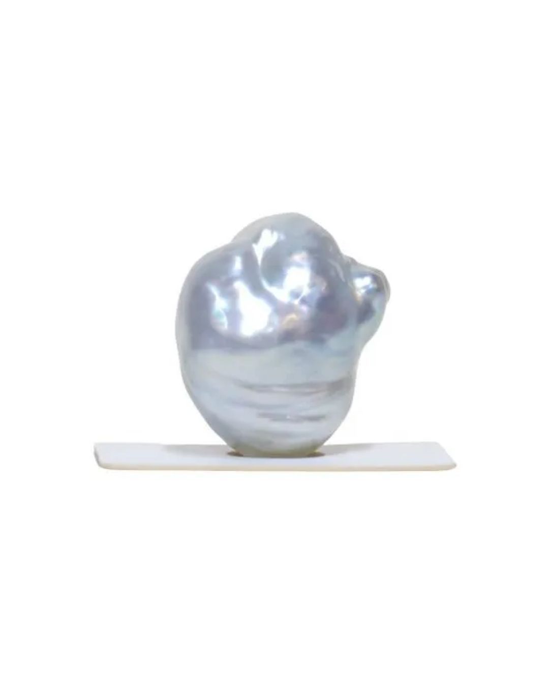 A lustrous, irregularly shaped, pale blue baroque pearl sitting on a small white stand against a white background.