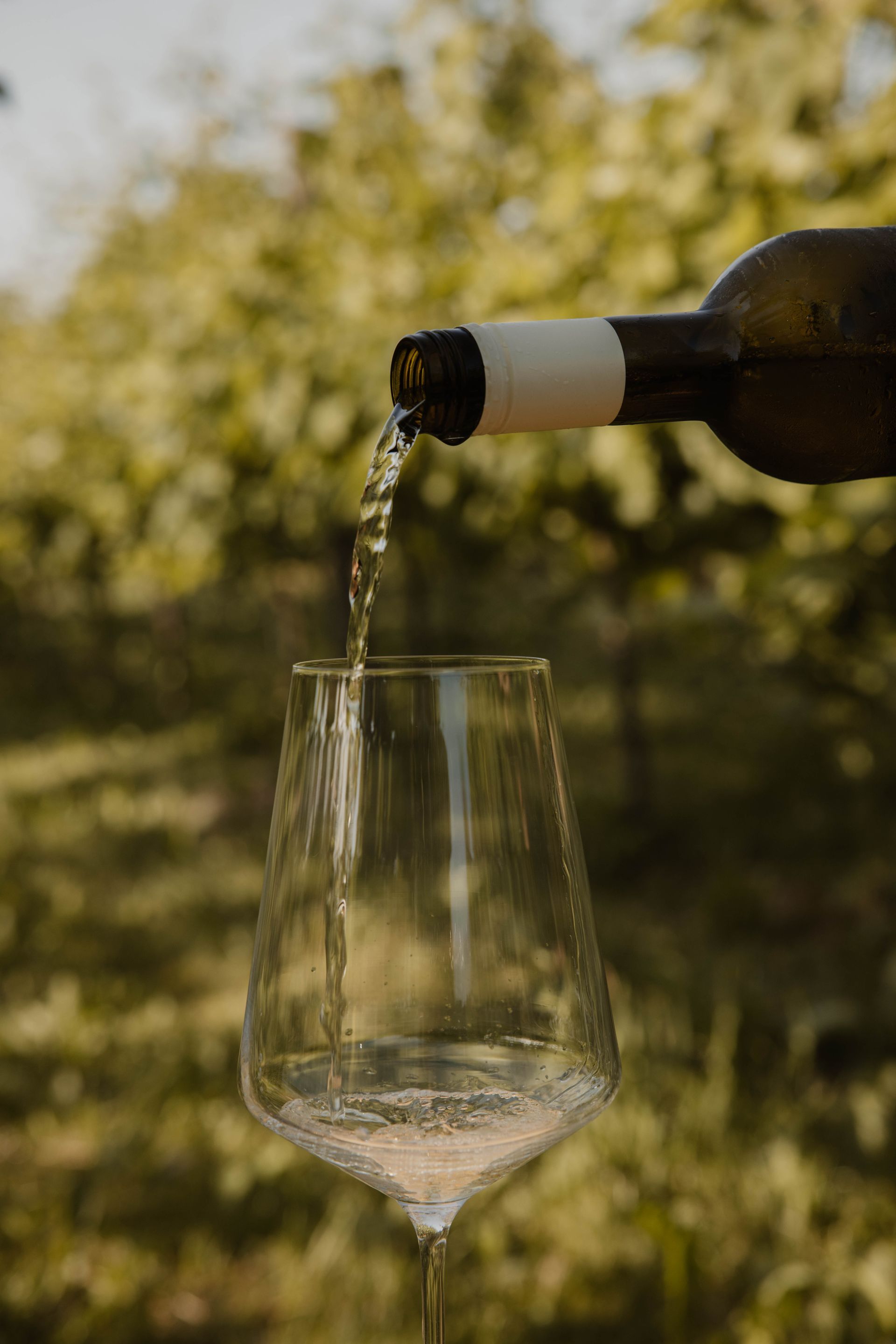 Close-up van een donkergroen shirt met een klein logo en een blonde haarlok aan de rechterkant.