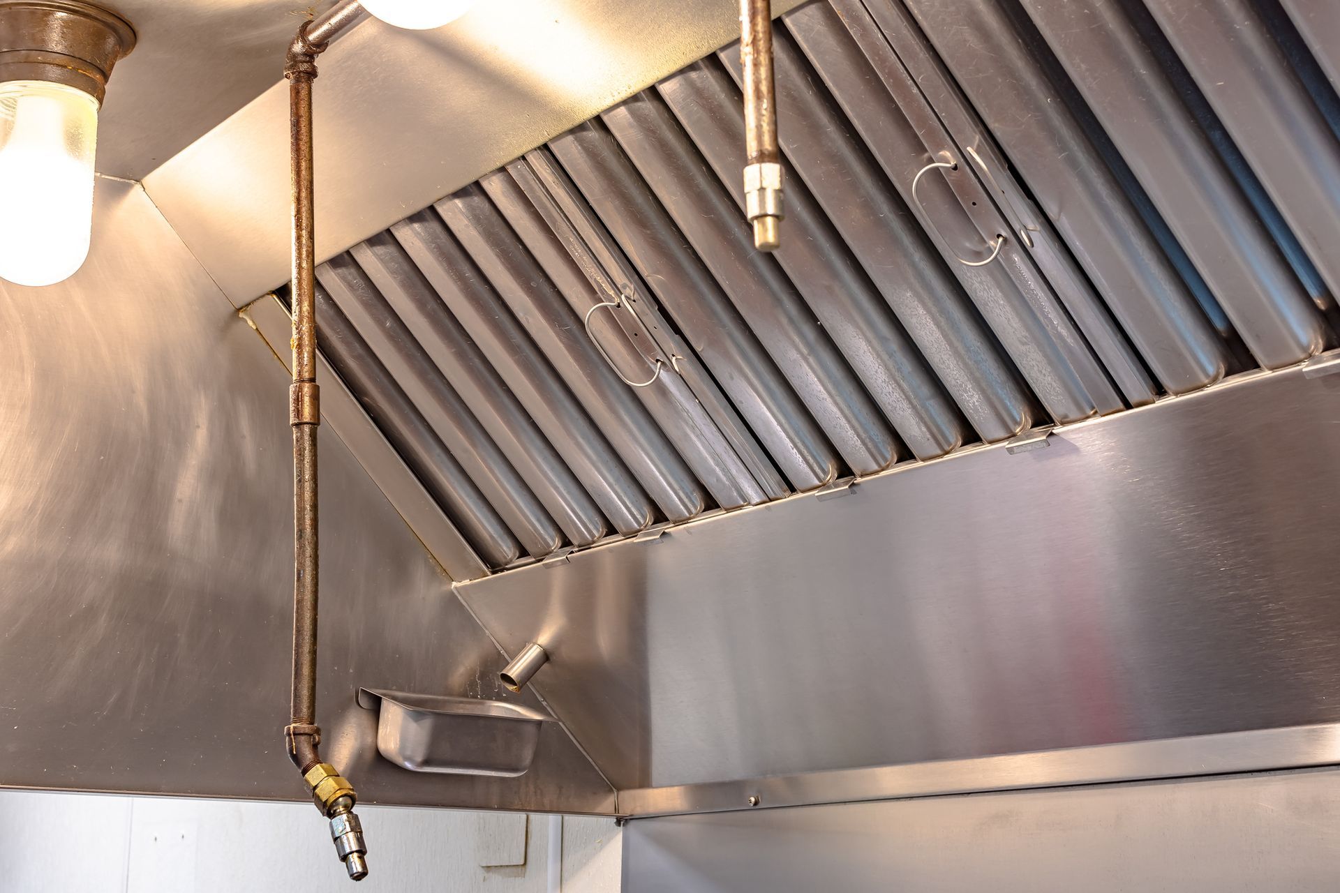 A stainless steel hood with a hose attached to it. A stainless steel hood with a hose attached to it.