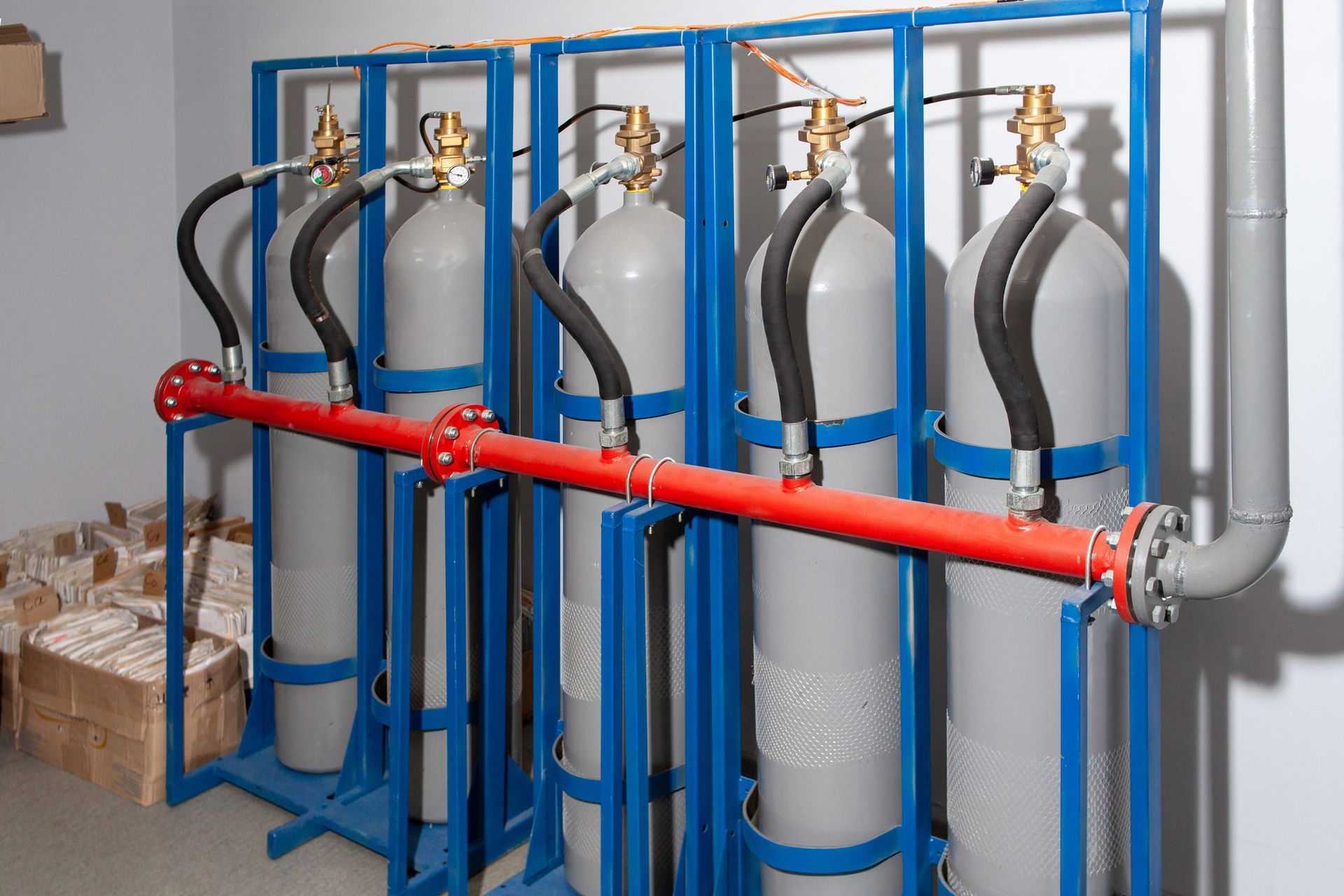 A row of gas cylinders are lined up in a room. A row of gas cylinders are lined up in a room.