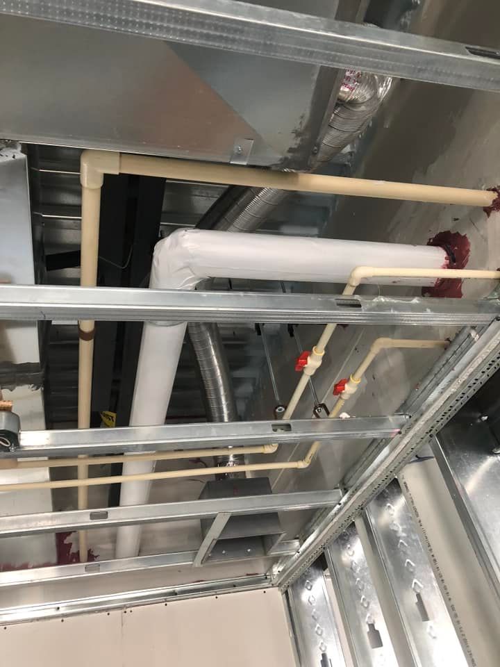 A bunch of pipes are hanging from the ceiling of a building.