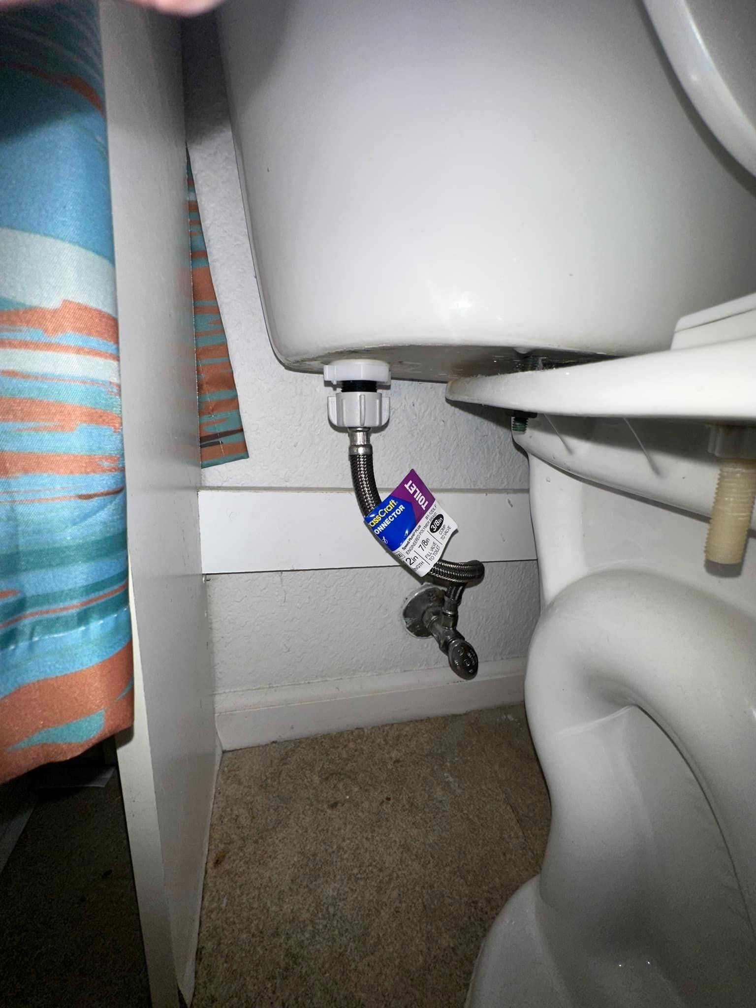 A toilet with a hose attached to it.