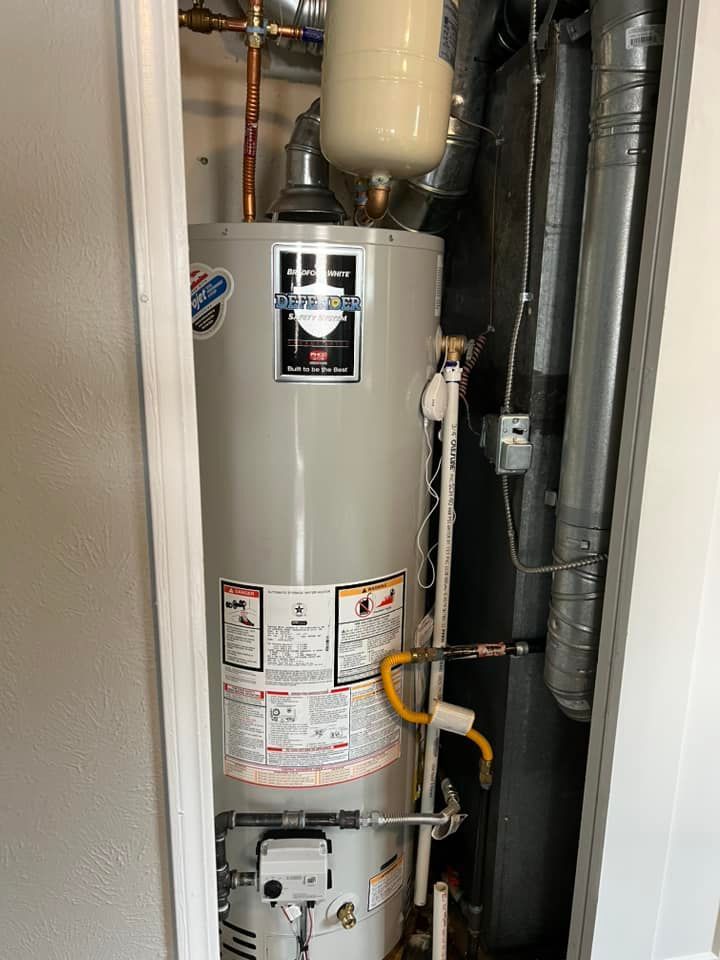 A water heater is sitting in a closet next to a wall.