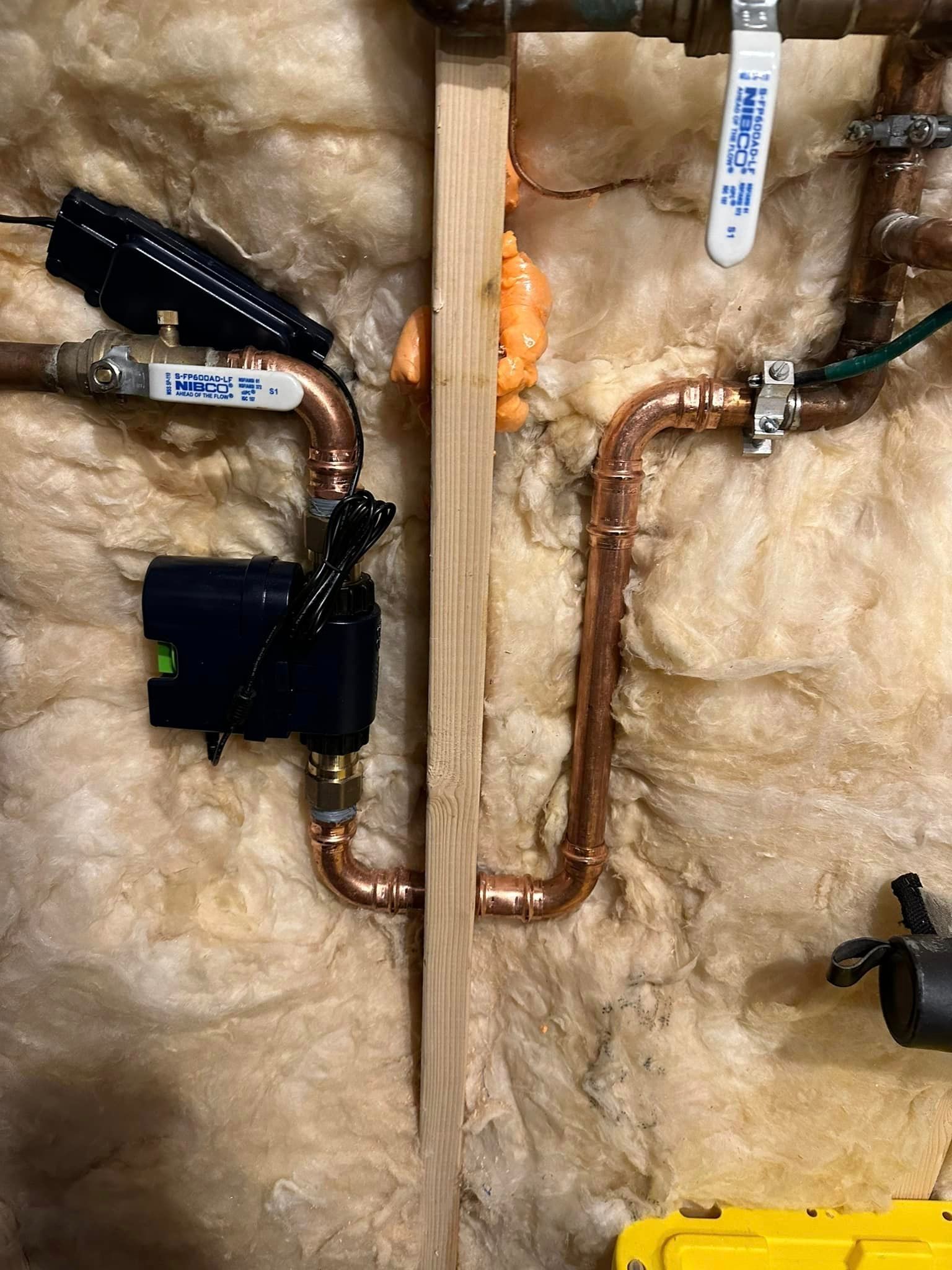 A close up of a copper pipe on a wall.