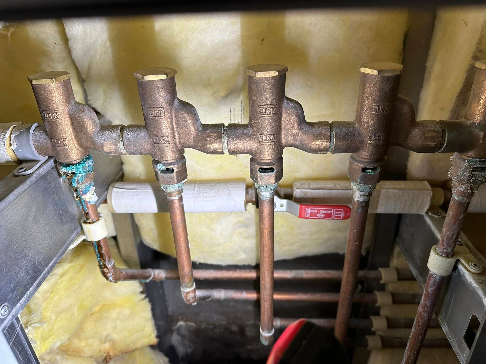 A bunch of copper pipes are connected to each other in a room.