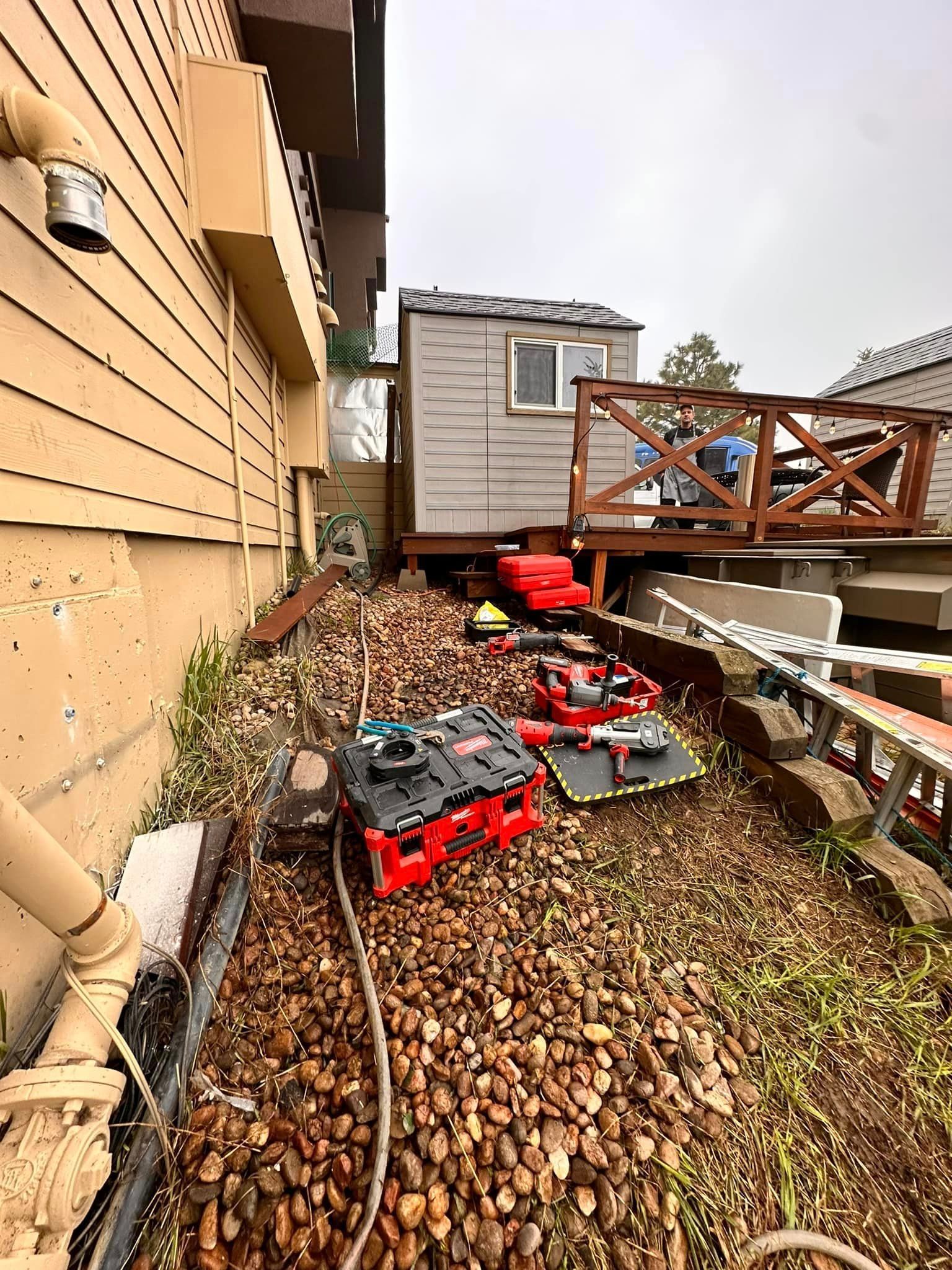 A bunch of tools are sitting on the ground in front of a house.