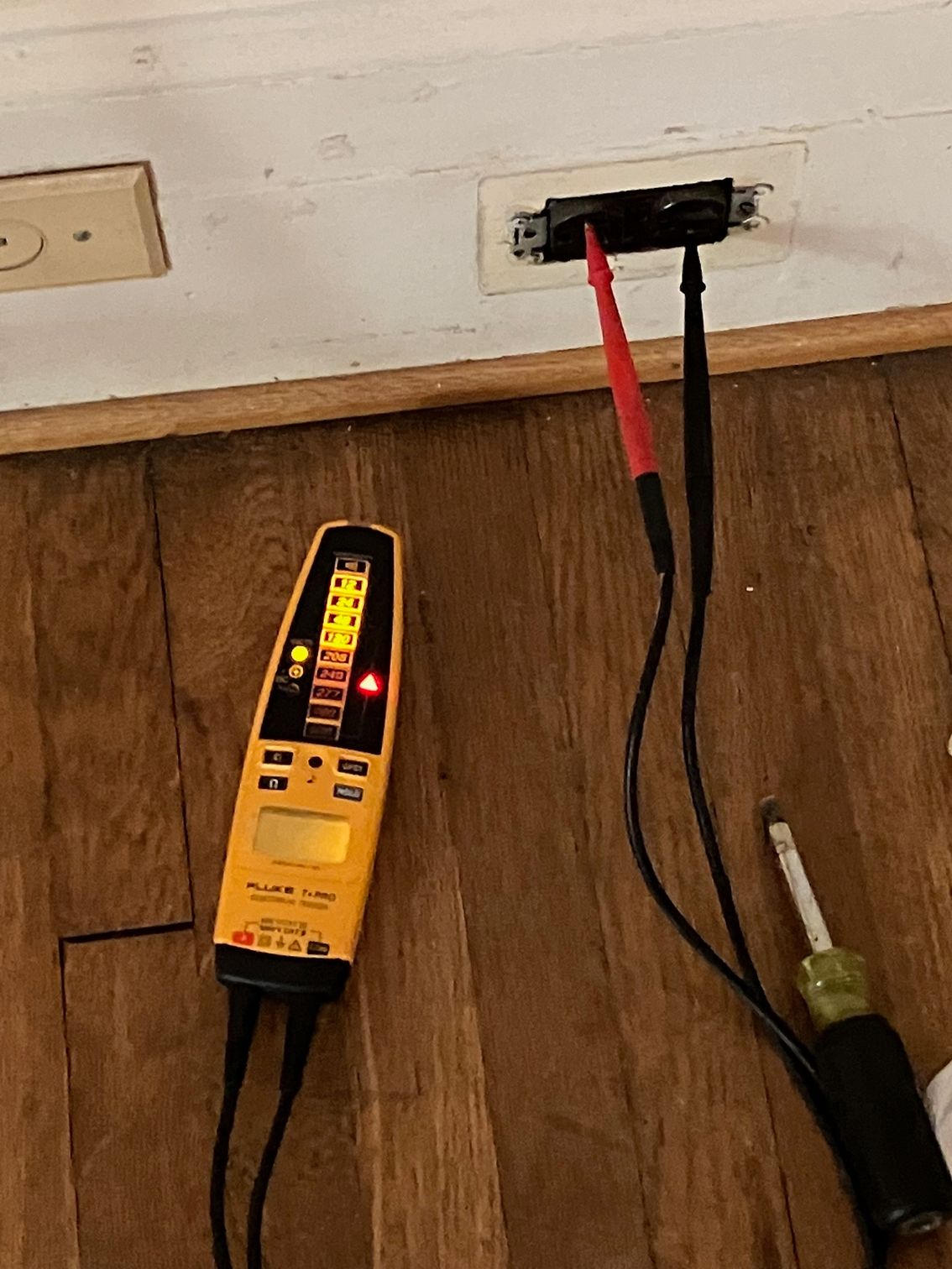 A voltmeter is plugged into a wall outlet