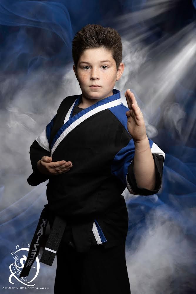 Young child in white gi practicing karate stance with instructor at Kaizen Academy Lil' Dragons program in Gilbert, AZ