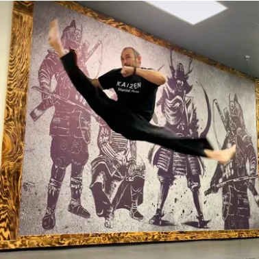Adult student practicing martial arts fitness training with a black belt instructor at Kaizen Academy in Gilbert, AZ