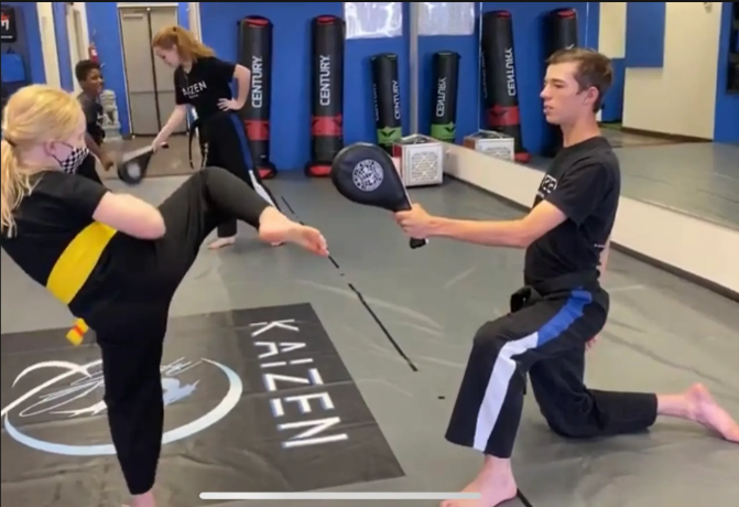 Masters Program student mentoring a junior student at Kaizen Academy martial arts studio in Gilbert